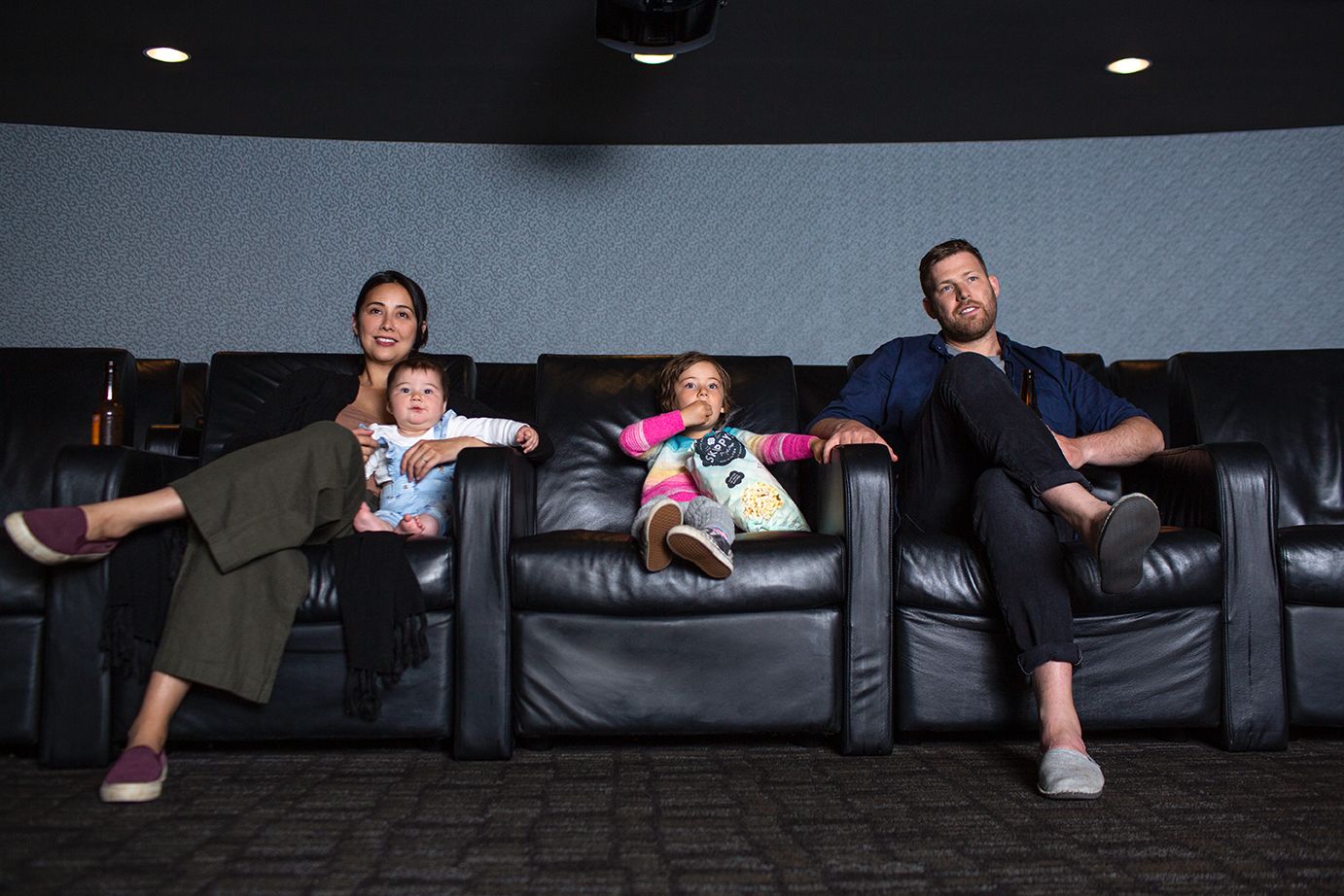 A Man And Woman With Two Children On A Couch